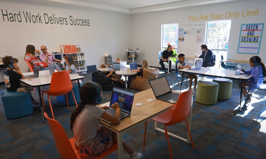 Students engaged in focused learning, utilizing laptops in a modern classroom setting