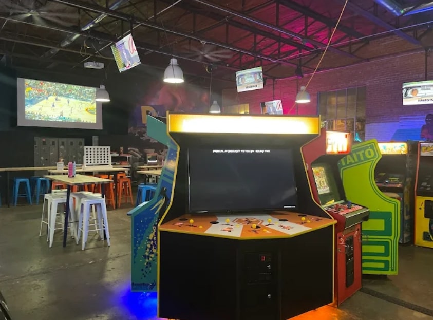 Retro-style arcade with multiplayer game stations at Round Two