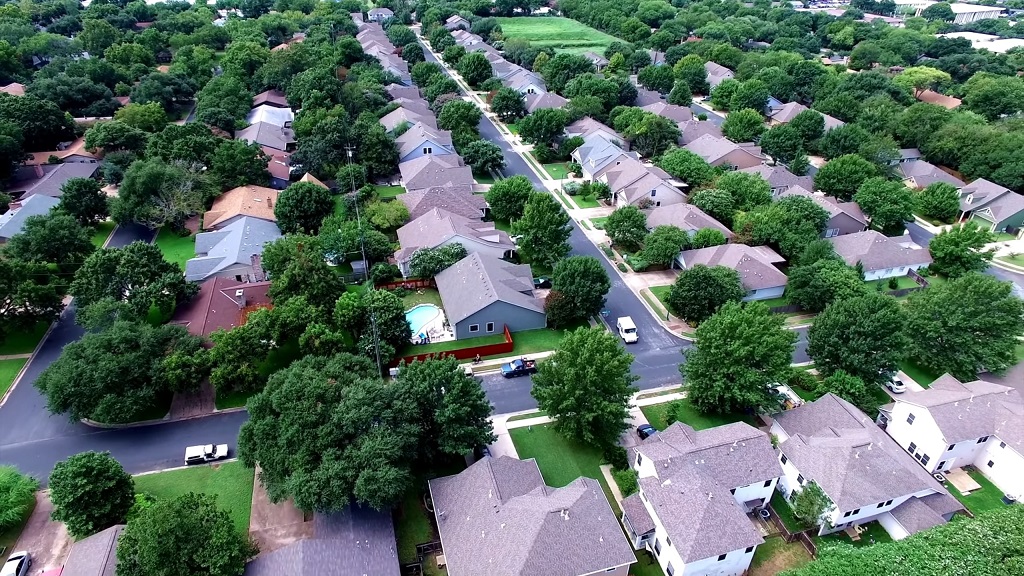 Overhead photo of suburban street lined with houses, illustrating housing market growth