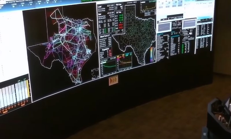 A man gazes at a large screen displaying a detailed map
