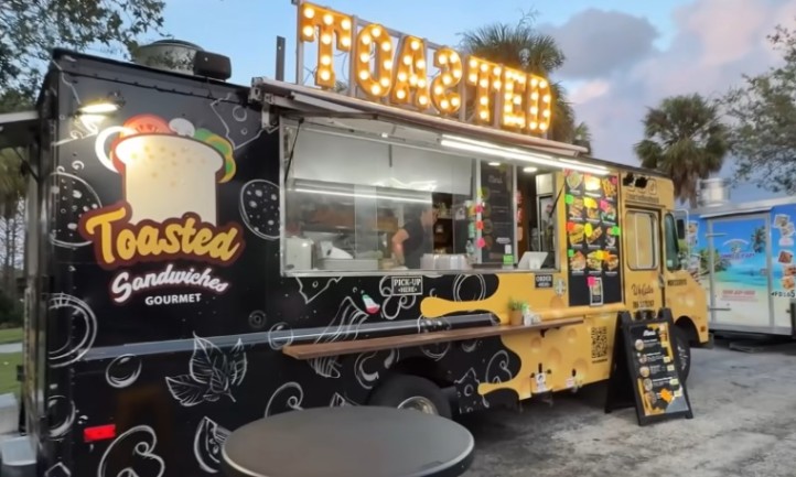 A food truck featuring a sign that reads "Toasted Sandwich," showcasing its menu item prominently